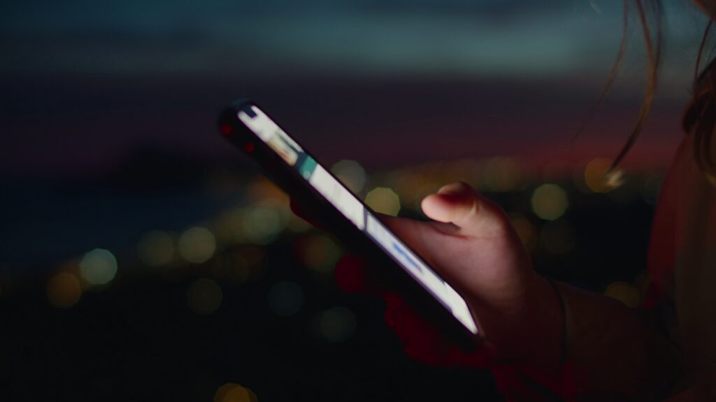 person holding smartphone, looking to contact and inquire about a service